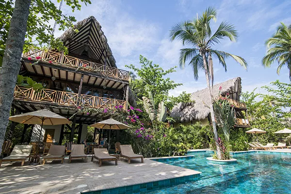 villa next to pool with palm trees