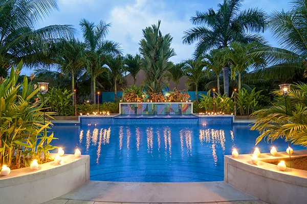 swimming pool surrounded by candles and palm trees