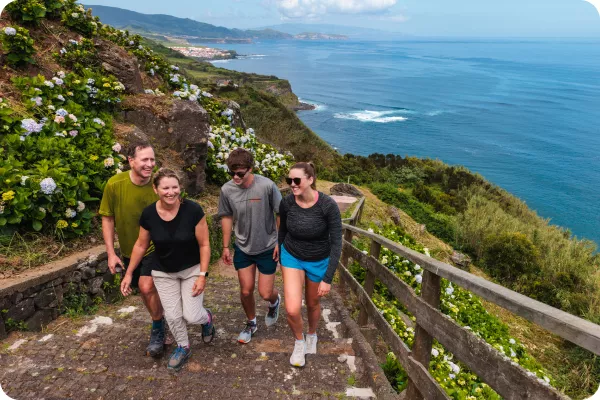 Family hiking along a seaside cliff in the Azores