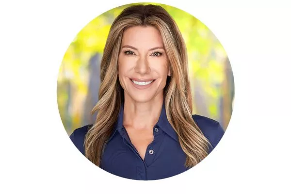 Portrait of a woman in a black blouse, smiling at the camera