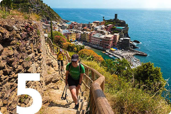 text:5; image: hikers climb up a rocky staircase overlooking water