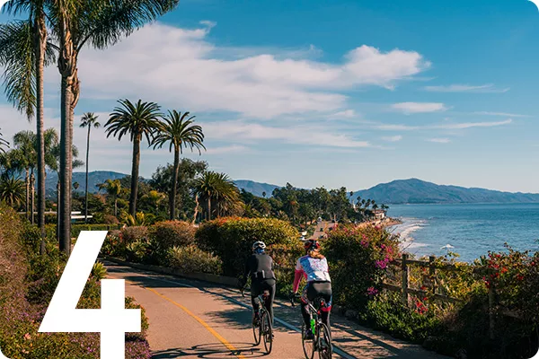text:4; image: bikers cycling down a road surrounded by palm trees