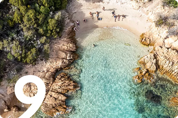 text:9; image: Aerial shot of beachgoers lounging on the sand
