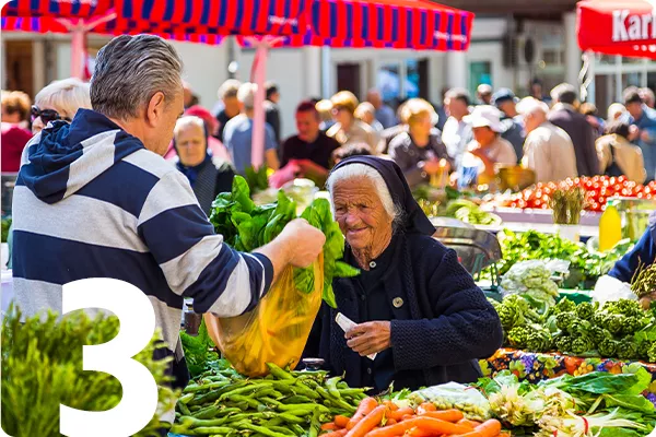 text:3; image: a woman buying produce at an outdoor market in Croatia