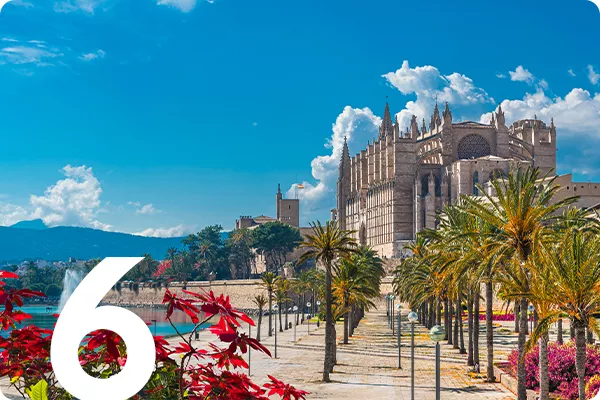 text:6; image: Building with palm trees and a blue sky in Mallorca