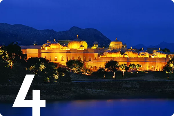 text:4; image: A building is lit with yellow lights against a dark sky