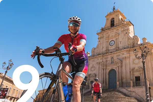 text: 9; image: person riding back in front of old church