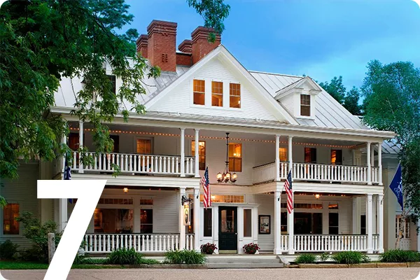 text:7; image: Large white house with balconies and American flags out front