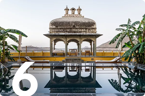 text:6; image: a poll surrounded by lounge chairs and an embellished cabana