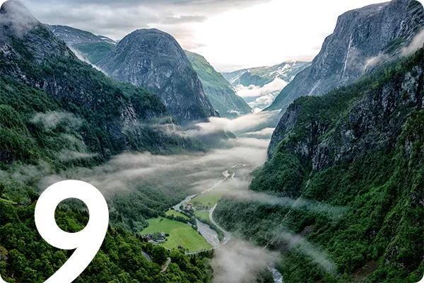 text:9; image: fog rolling over green mountain peaks