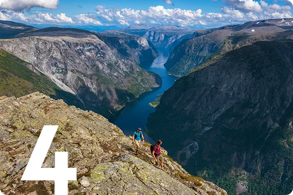 text:4; image: two people hike along a river's cliff