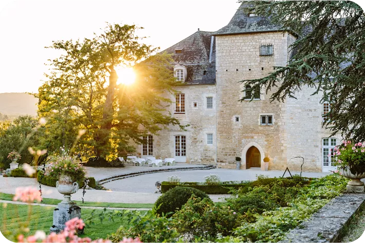 Exterior view of stone building with a garden in front