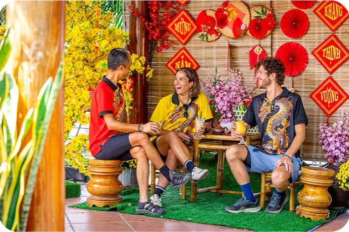 Group of people sitting in front of a wall full of Vietnamese art pieces
