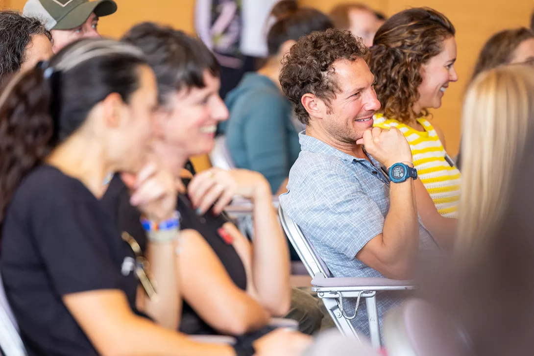 Group of people smiling while sitting, watching a lecture