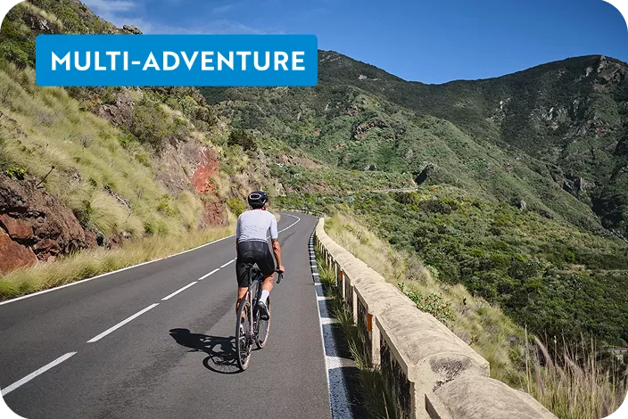 Person biking on an empty road on a hill