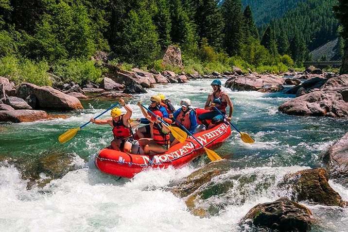 People rafting on a red boat in a river