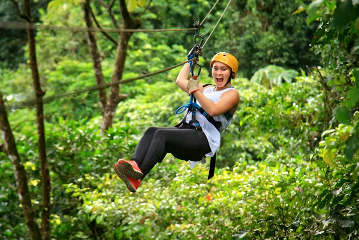 Girl laughing while riding a zipline