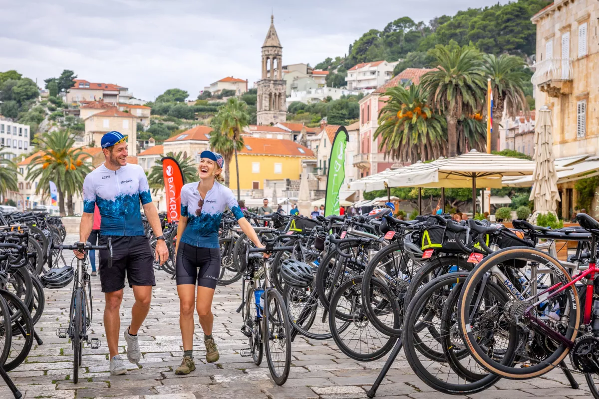 Man and woman walking next to a row of parked bikes