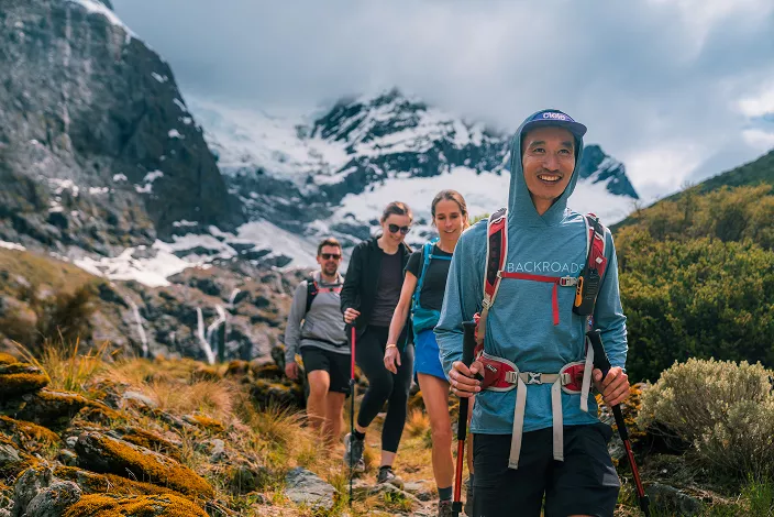 Group of people hiking with snow-capped mountains in the distance