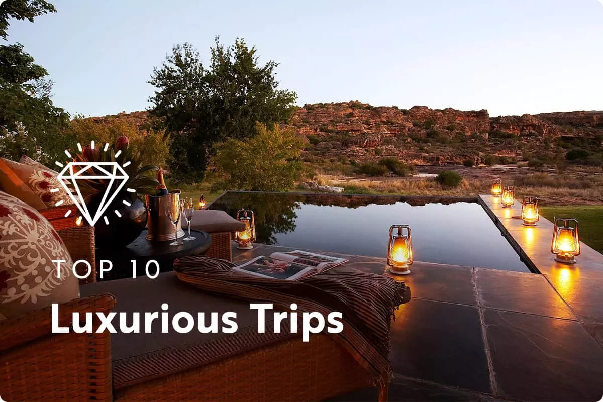 text: Top 10 Luxurious Trips image: Outdoor pool with a valley in the distance