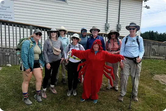 Group of people smiling with a person in a lobster suit