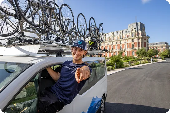 Man leaning outside of a van, pointing to the camera