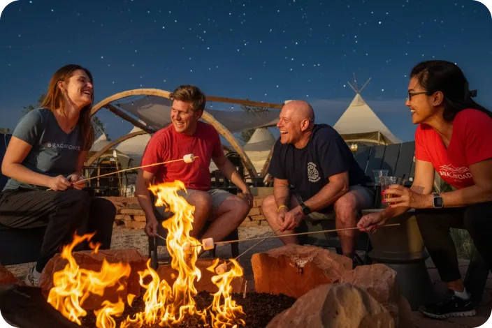 Group of people around a campfire, roasting marshmallows