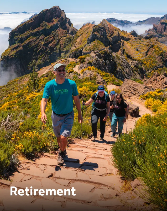 Group of people ascending a rocky hill on top of a mountain