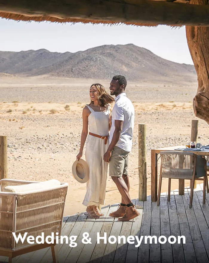 Man and woman standing in a patio, looking out towards a desert