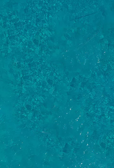 Swimmers swimming next to a boat in Crete, Greece