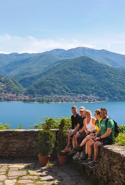 Small group sitting on ledge near a lake