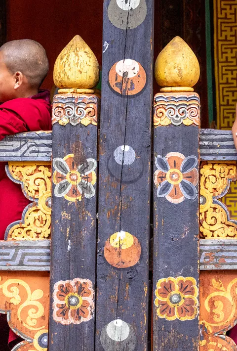 Tibetan Monks leaning over railing and talking to each other