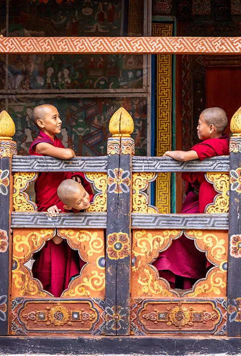 Monks leaning over railing and talking