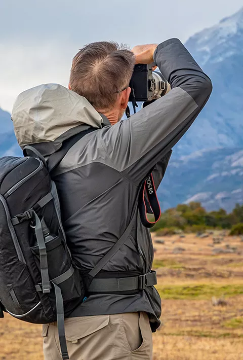 A man with a camera photographing a mountain