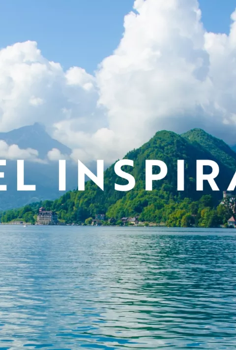 Blue water with mountain in the background with text overlay "Travel Inspiration"