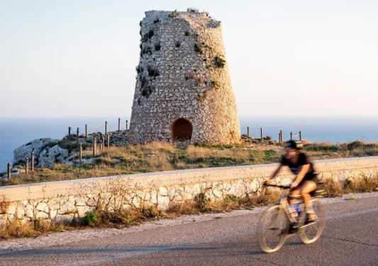 Backroads rider cycling past old stone ruin