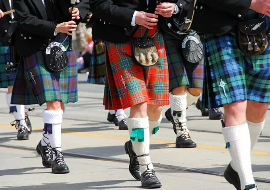 Troupe of bagpipers playing while marching