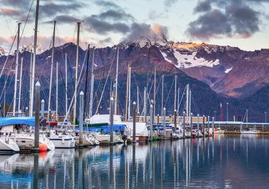 Shot of boat line at pier during sunset, mountain in distance.