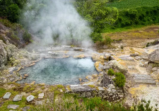 Natural geyser of boiling mineral water and evaporation, located at side of Furnas town on Sao Miguel island of Azores, Portugal. 