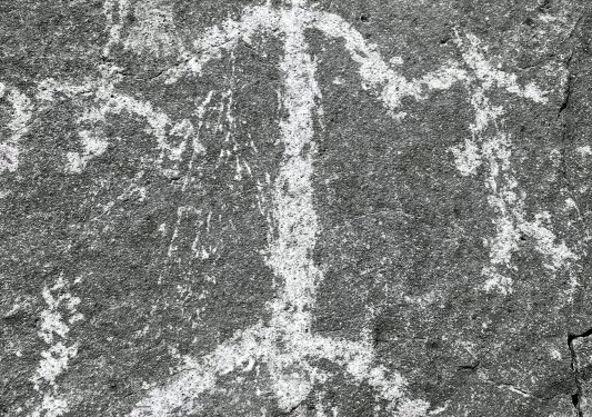 Shot of rock etching, human forms.