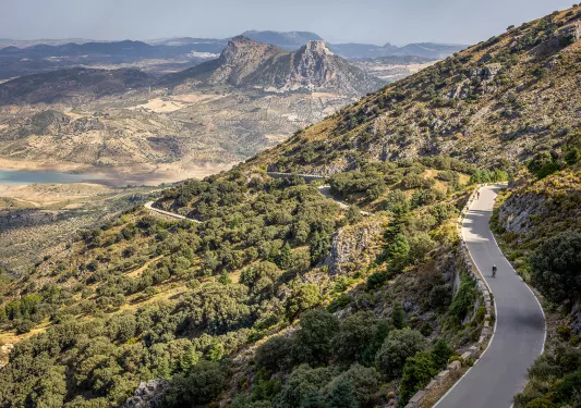 Two Backroads' guests biking on road in mountains, Spain.