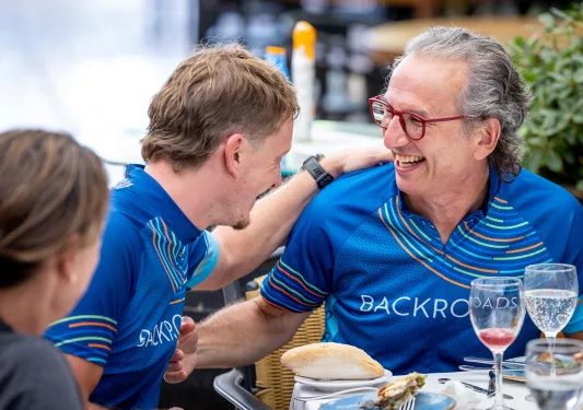 Backroads guests at a meal in their jerseys after a bike ride.