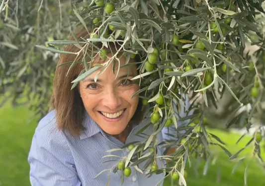 Woman posing with olive tree.