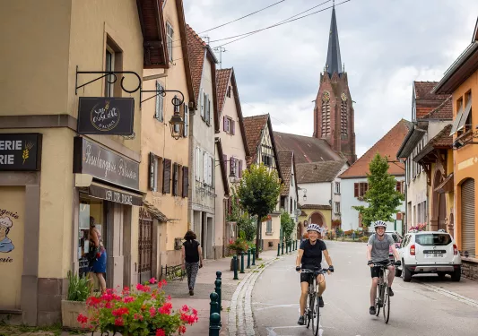 Two Backroads Guests Biking Through Town in Alsace