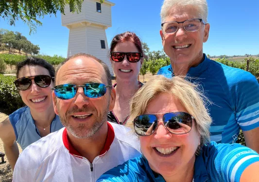 Guest selfie with vineyard and building in background.