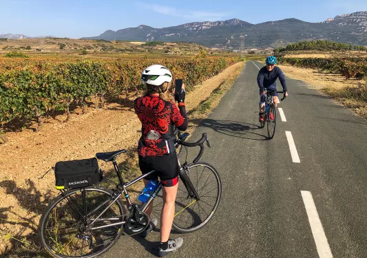 Backroads Guest Taking the Photo of Another Backroads Guest Biking Through a Vineyard