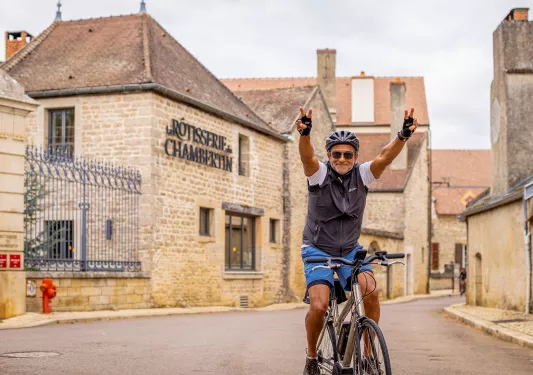 Backroads Guest Holding Up Peace Signs While Biking