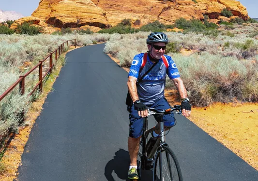 Smiling biker on road with mountain in backdrop