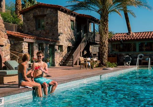 Guests relaxing poolside at desert resort.