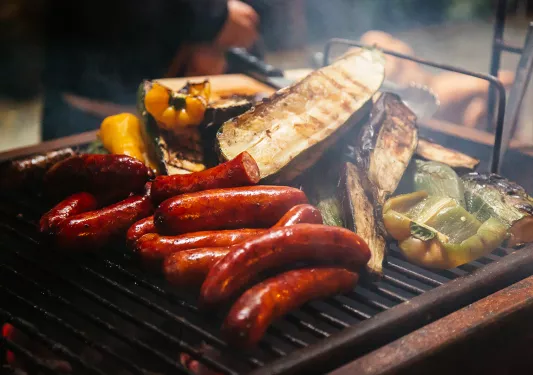 Close-up of searing sausages and veggies.